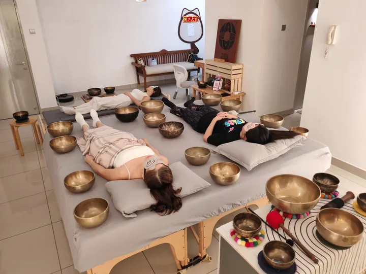 三人颂钵疗愈现场,三位体验者在颂钵环绕中放松
